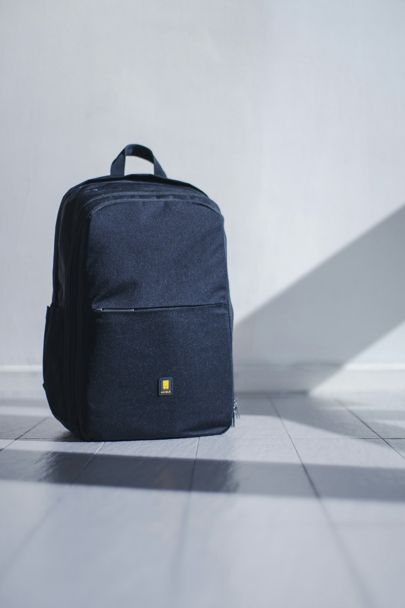 Mochila azul marino sobre un piso claro