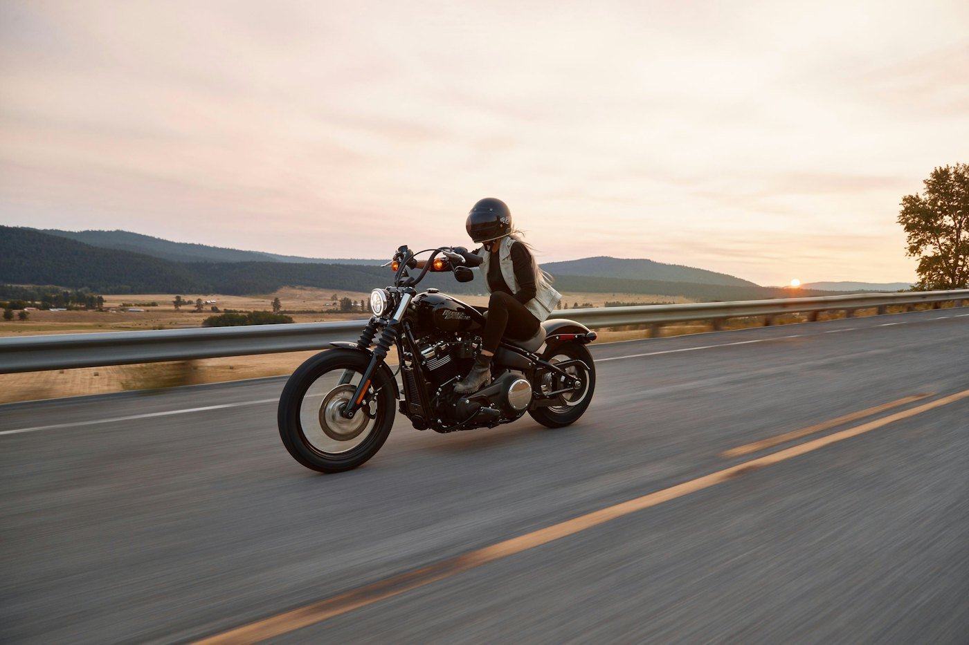 Motociclista en carretera al atardecer